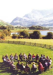 group of people sitting in a circle in a rural setting